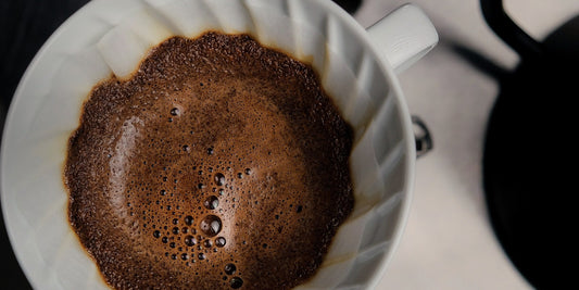 A Hario V60 pour-over blooming with fresh coffee, seen from above